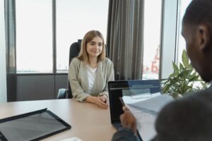 Types of job interview. Young woman sat facing interviewer looking comfortable and smiling.