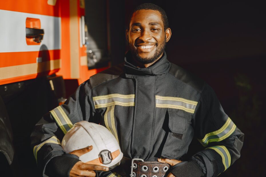 Fire safety quiz - happy fireman smiles at the camera next to a fire truck